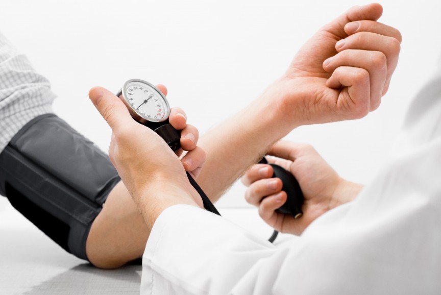 Doctor measuring blood pressure - studio shot on white background